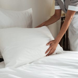 Housekeeper fluffing pillow