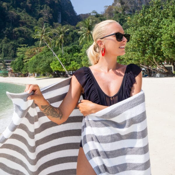 Woman wrapped in California Cabana Towels - Grey on the beach