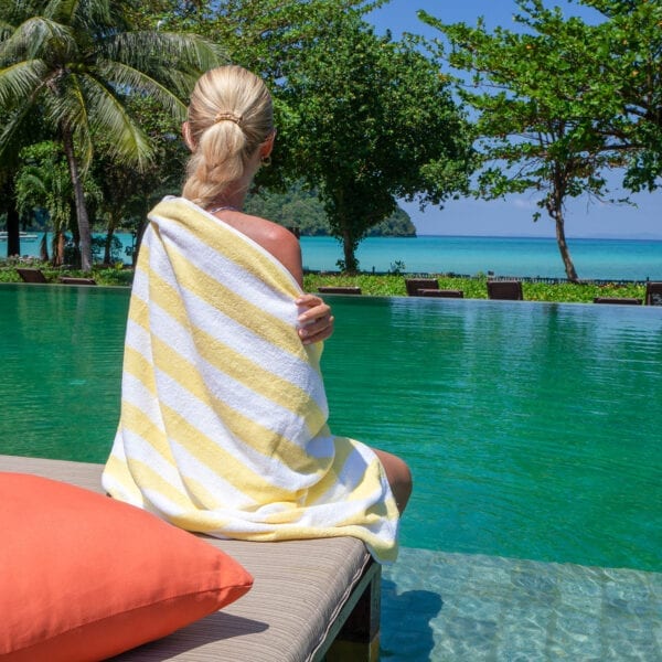 Woman wrapped in California Cabana Towels - Yellow sitting by the pool