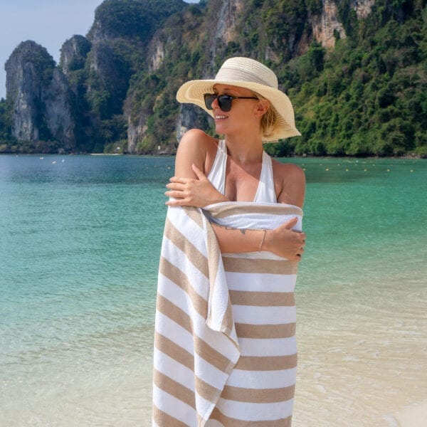 Woman wrapped in California Cabana Towels - Beige by the ocean