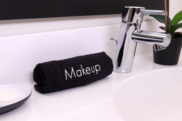 Terry Embroidered Makeup Removal Washcloths rolled up on bathroom counter