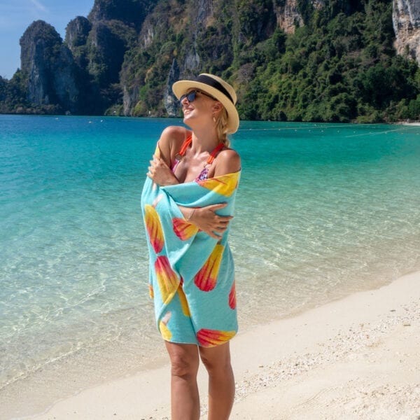 Woman wrapped in Printed Beach Towel - Popsicles standing by the ocean